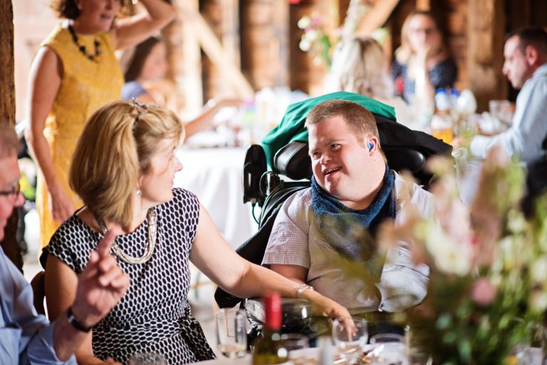Wedding guests smiling at each other and having a good time at Overbarn, Gloucester