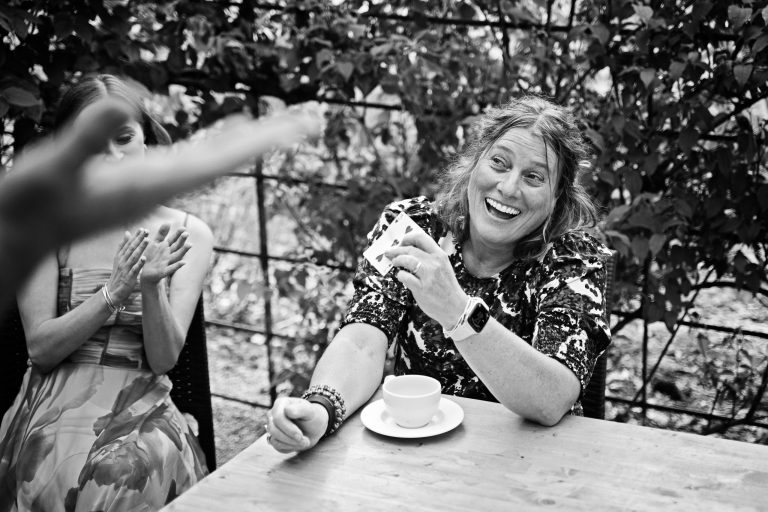 A b&w image of a wedding guest that is being entertained by a magician