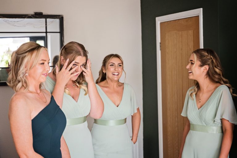 bridesmaids crying in emotion after seeing the bride for the first time.