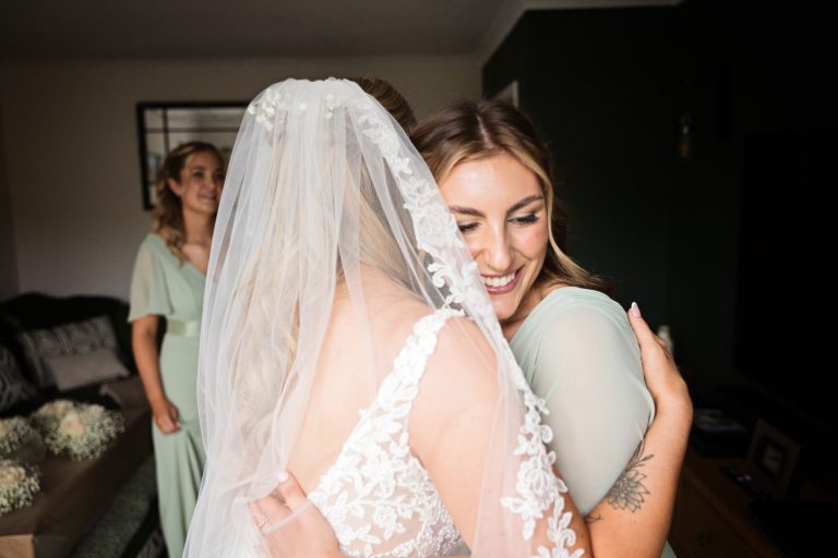 bridesmaid hugging the bride