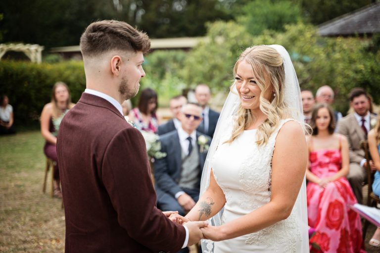 bride and groom hold hands smiling