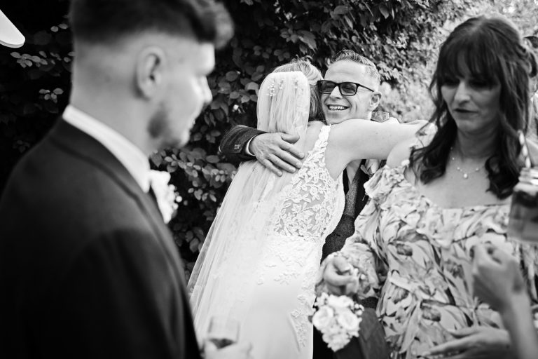 b&w image of a bride being hugged by her new father in law