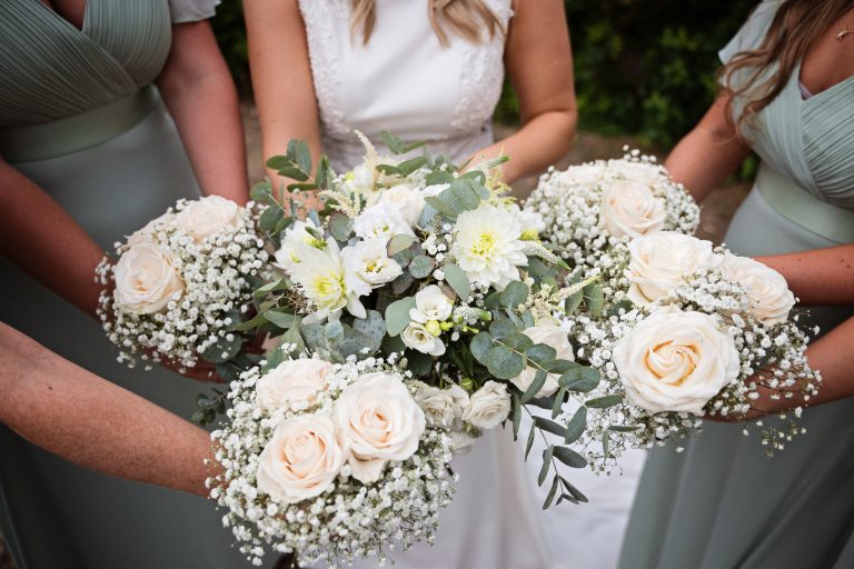 the bridal bouquet and bridesmaids flowers bunched together.