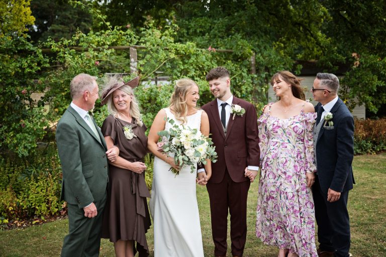 fun family wedding group photo of everyone smiling at each other.