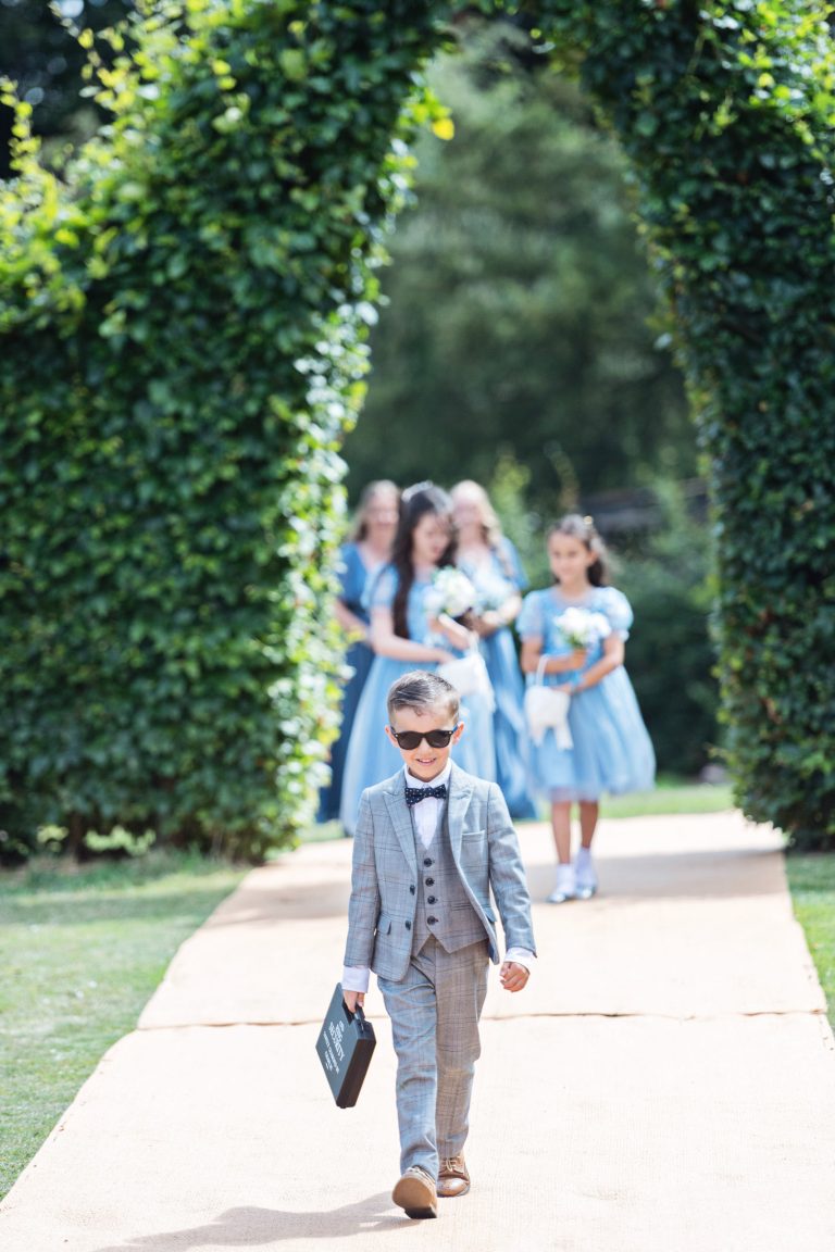 A ring bearer (son of bride and groom), looking very cool as he carry's a briefcase (with the rings), down the wedding isle