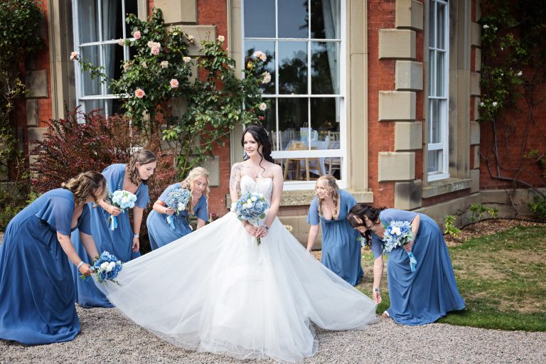 Bridesmaids fanning the brides dress out at Homme House.