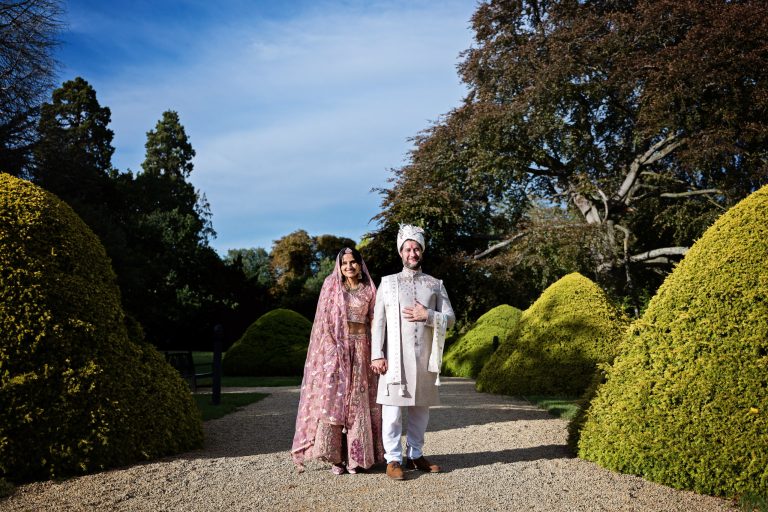 Couple shot, in Indian wedding attire by Cotswold wedding photographer taken at Manor By The Lake