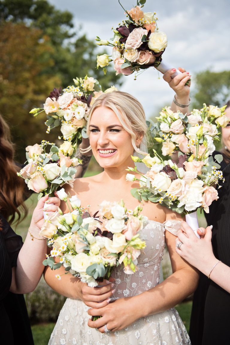 Fun photo of bride being surrounded by her bridesmaids flowers