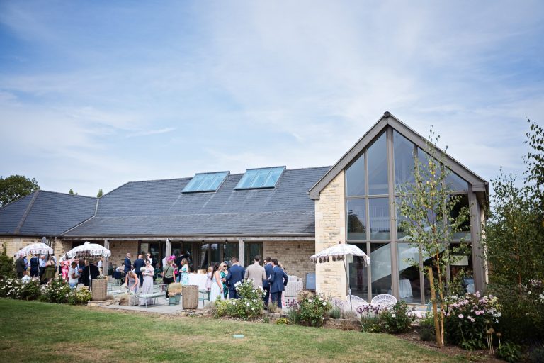 Exterior photograph of the grounds at Blackwell Grange with wedding guests chatting