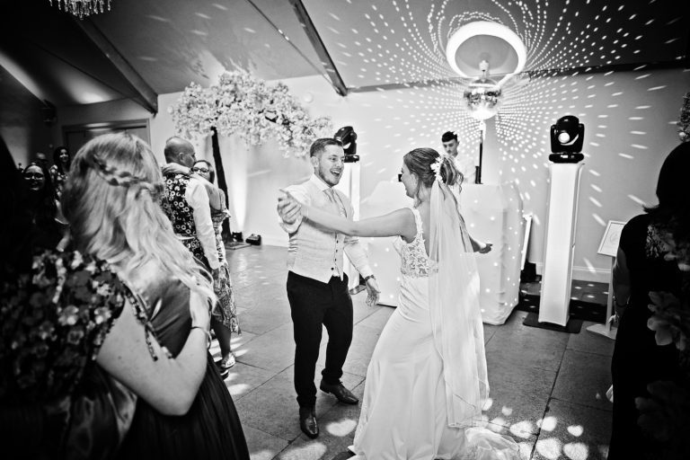 B&W fun photo of bride and groom doing their first dance at Blackwell Grange