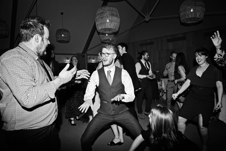 B&W image of groom doing some dance moves.
