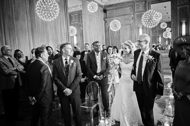 Bride walking with her dad down the wedding isle, getting her first look with her husband to be.