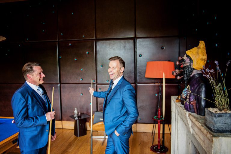 Groom and best man playing pool.