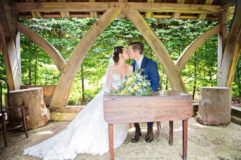 Bride and groom kiss after they have signed the wedding register.