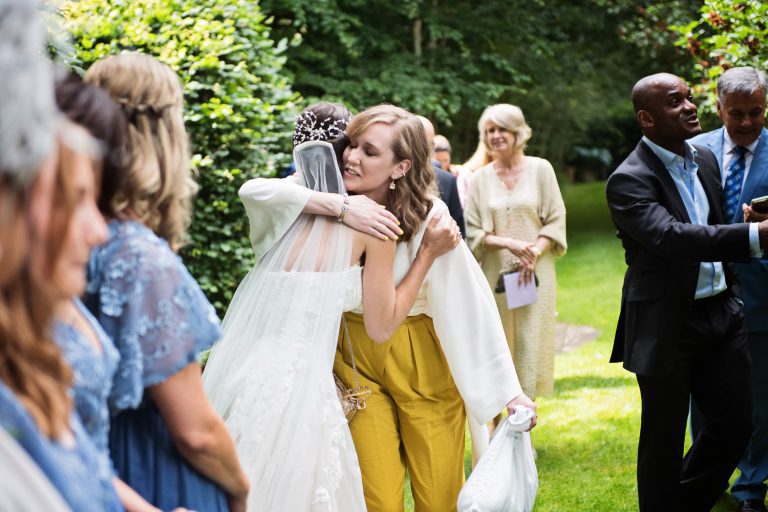 Candid photo of a wedding guest hugging the bride.