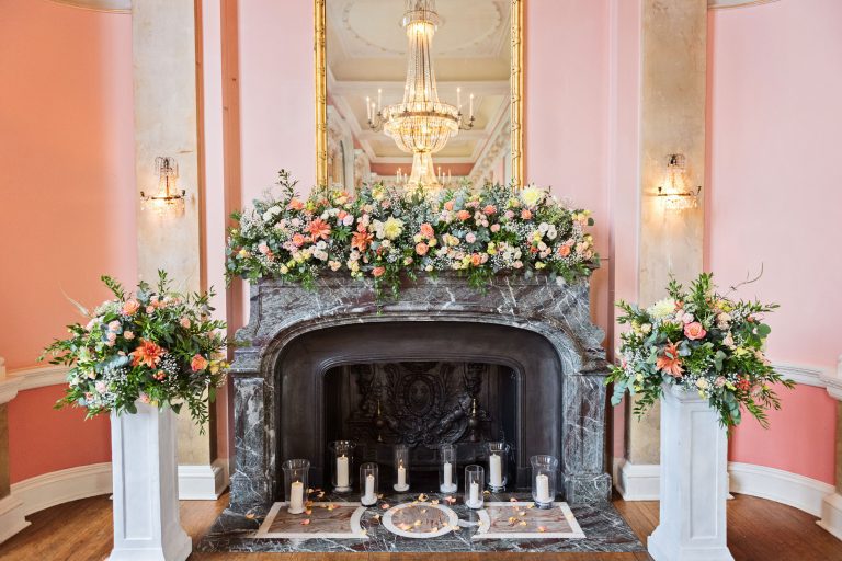 Large fireplace with stunning wedding flowers and candles.