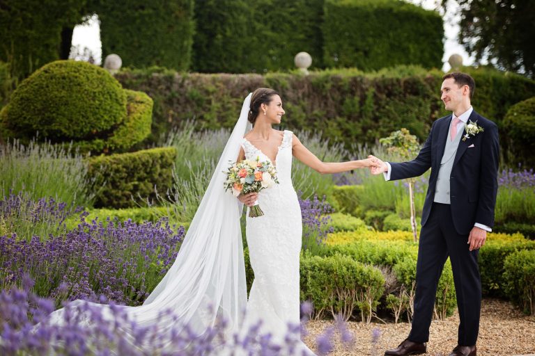 Bride and groom stand in the impressive grounds at Danesfield House.