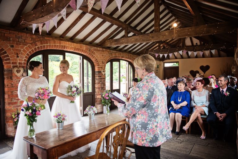 Wedding taking place at Dodmoor House. Family and friends look onward at the bride and bride getting married.