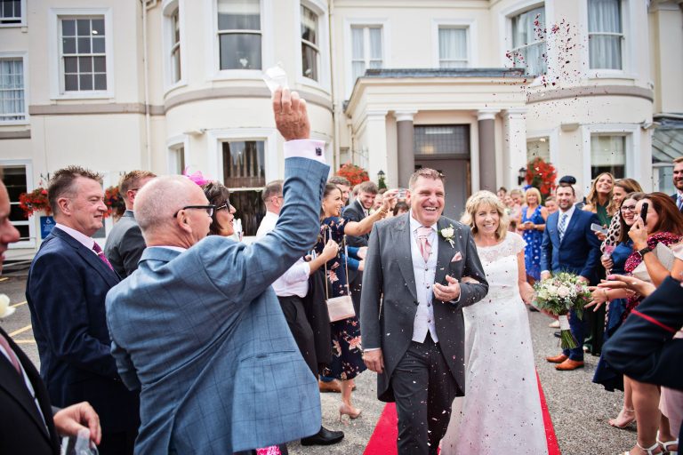 Confetti being thrown over bride and groom outside the front of Double Tree Hilton, Cheltenham.