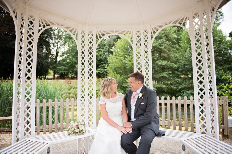 Bride and groom have an intimate moment together underneath a pergola at Double Tree, Hilton, Cheltenham.