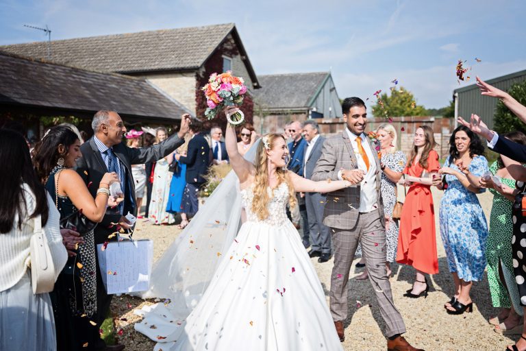 Bride and groom walk through the confetti isle