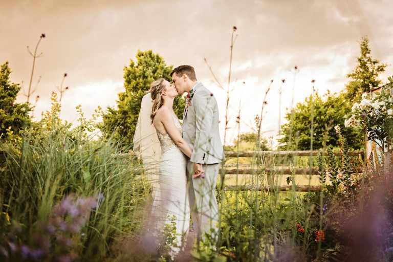 Bride and groom kissing in the garden.