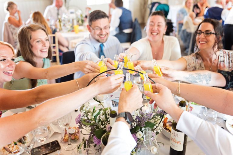 Guests celebrating the wedding with a very small bottle of limoncello.