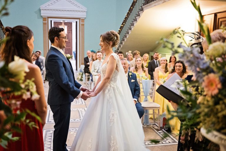 Bride and groom hold hands and exchange wedding vows.