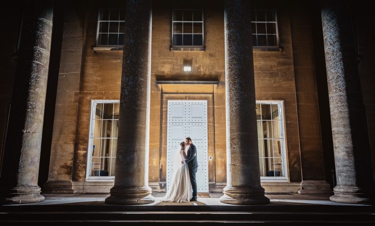 Exterior night time shot of bride and groom lit up by off camera flash at the top of the stairs at Leigh Court.