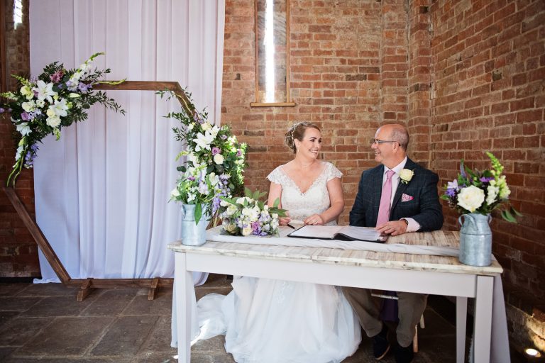 Bride and groom sign wedding register.