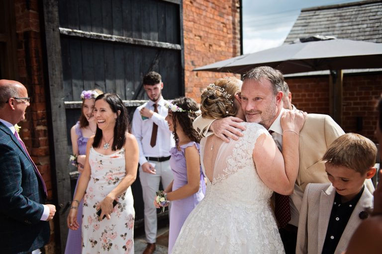 Bride getting hugged and congratulated by her friends at her wedding.