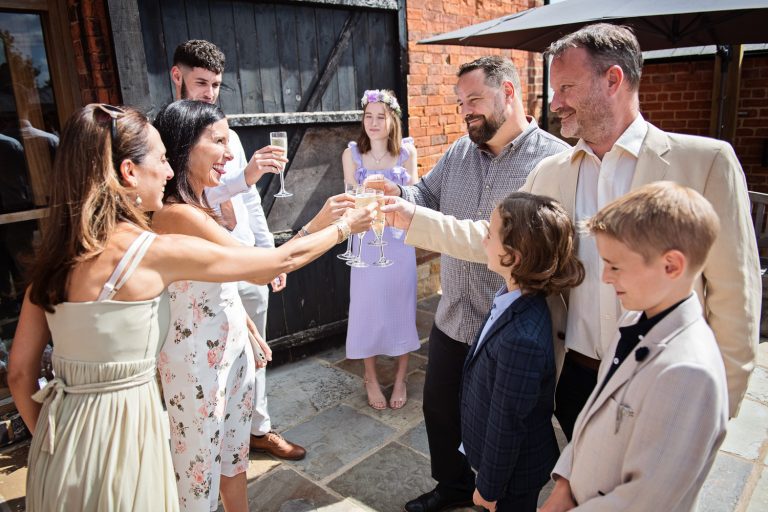 Wedding guests grab their champagne glasses and cheers each other.