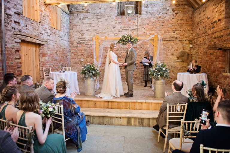 A wedding ceremony with the guests clapping.