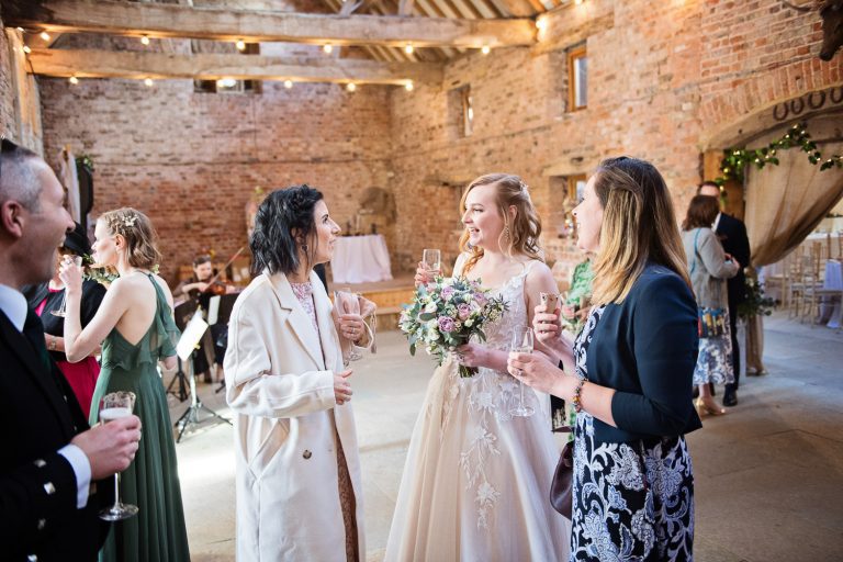 Natural photo of bride chatting to her friends after the wedding ceremony.