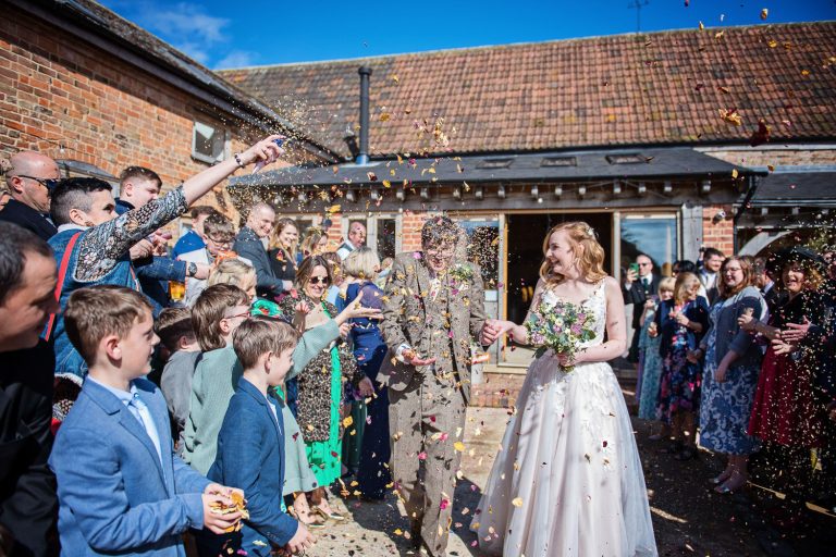 Confetti shot with the groom getting completely showered by friends and family.