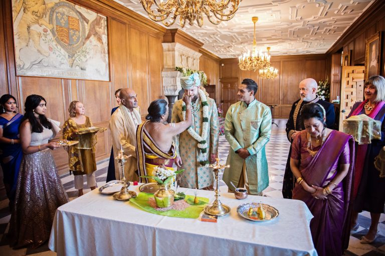 Groom having a bindi applied by the Pandit.