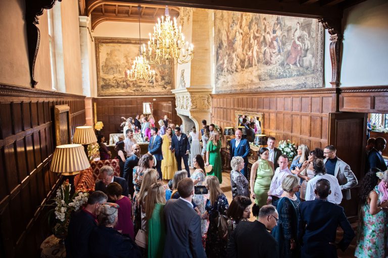 Guest mingle indoors in a state panel roomed hallway.