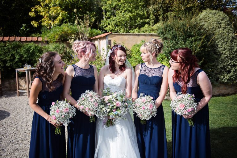 Bride and bridesmaids chatting and smilling.