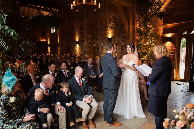 Bride and groom exchanging vows during their wedding ceremony at Shustoke Barn