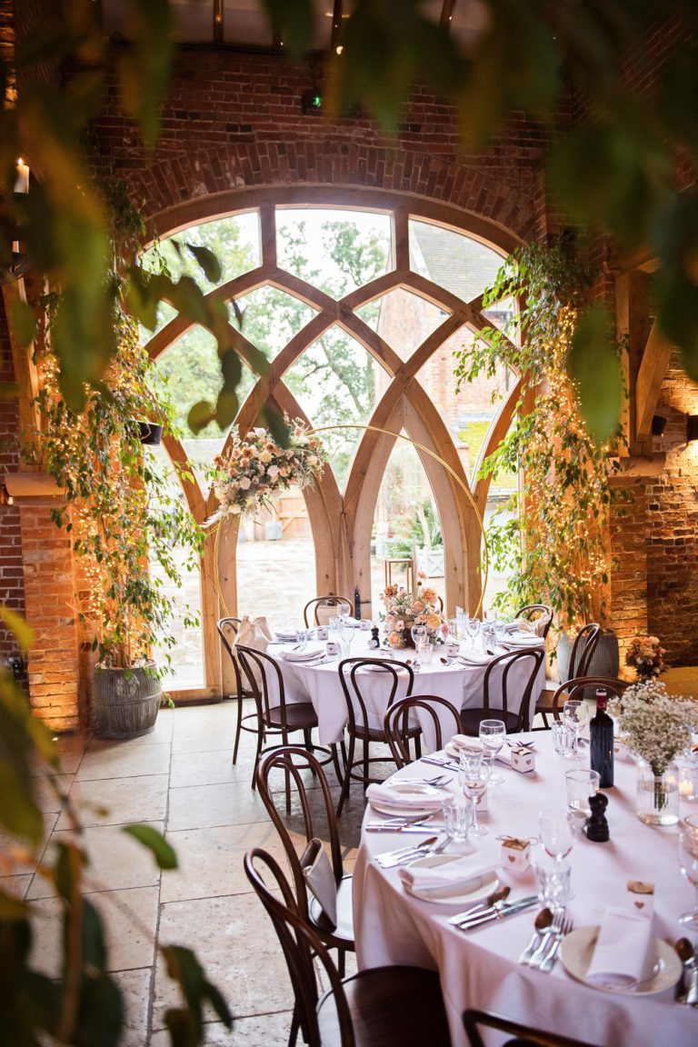 Portrait photograph of wedding breakfast table set up in a modern rustic barn.