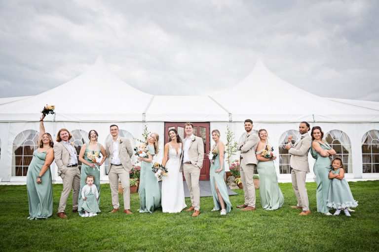 Bridesmaids and groomsmen pose in front of the new marquee.