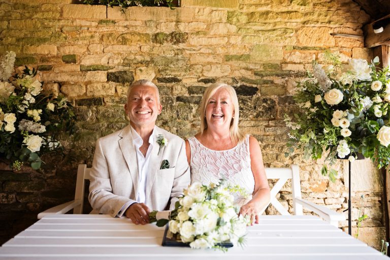 Bride and groom smiling after signing the wedding register.