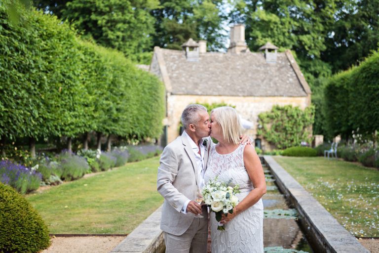 Bride and groom kiss in the garden.