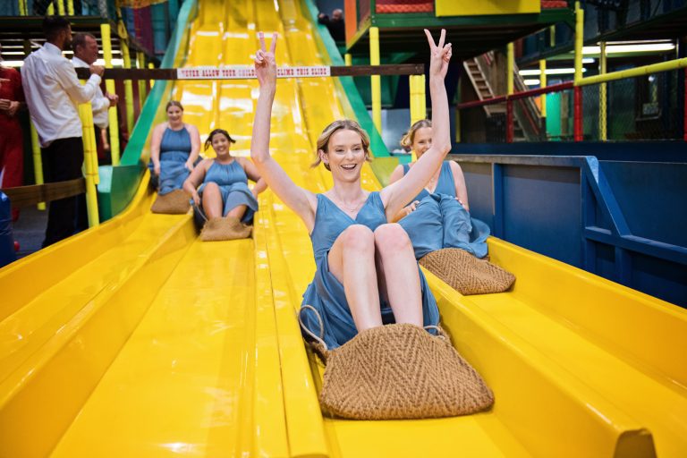Fun candid photo of the bridesmaids going down the slides at The Barn at Berkeley