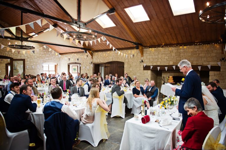 Candid photograph of father of the bride doing his speech to wedding guests.