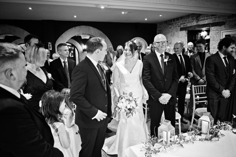 B&W candid photo of bride and groom first look during the ceremony