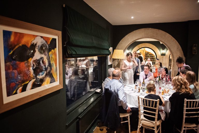 Candid photo of bride chatting to her wedding guests at The Bear at Rodborough.