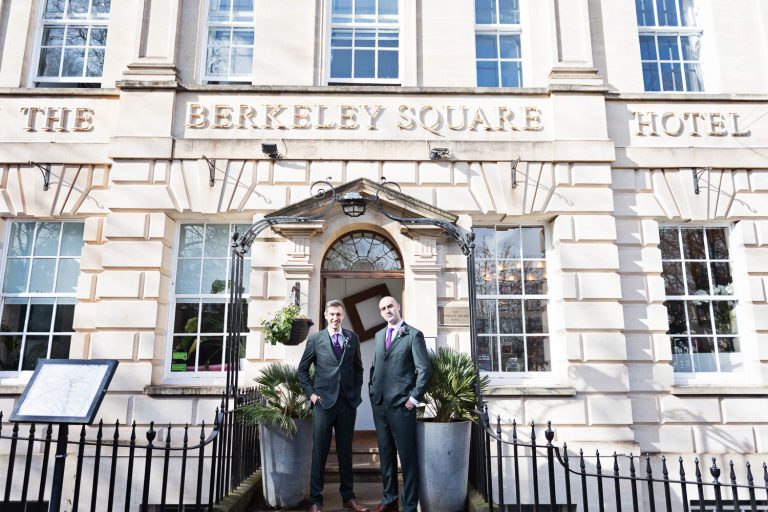 Groom and the best man stand outside the front of The Berkeley Square Hotel before a wedding.