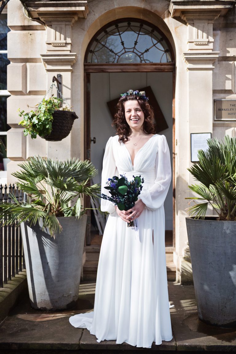 Portrait photo of the bride standing outside the front of the Hotel before her wedding.