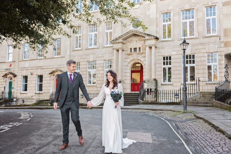 Relaxed and candid photo of bride and groom walking down the road, hand in hand at The Berkeley Square.